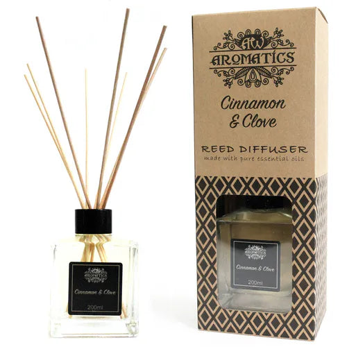 A "Cinnamon & Clove" reed diffuser and its brown cardboard box displayed side-by-side on a white background. The diffuser bottle and the packaging are both clearly visible.
