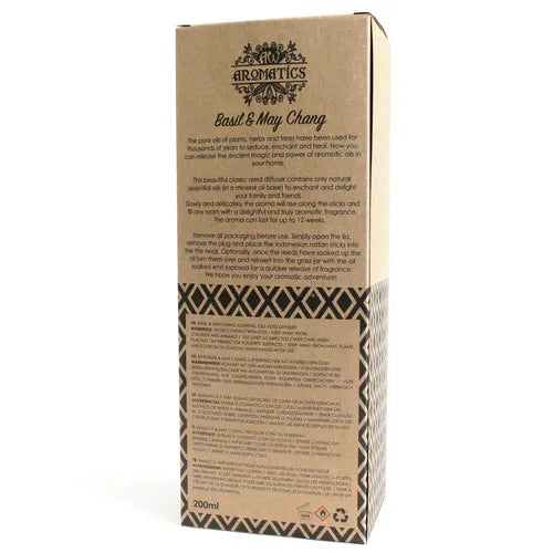 A detailed close-up of the back of a brown cardboard box for a "Basil & May Chang" reed diffuser. The box shows a product description, instructions for use, and safety warnings printed in multiple languages.