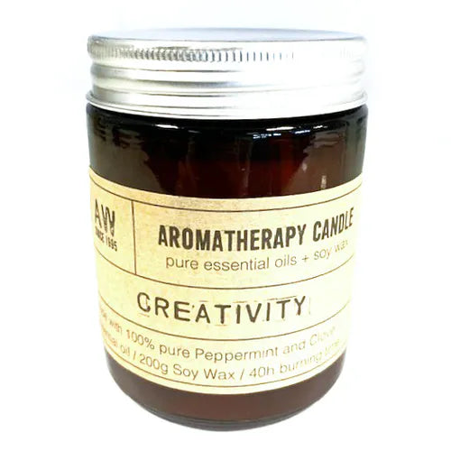 Amber glass jar labeled “Aromatherapy Candle – Creativity” with pure essential oils and soy wax, featuring peppermint and clove; closed with a silver metal lid.