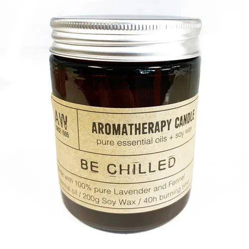 Brown glass jar of "Be Chilled" aromatherapy candle with lavender and fennel essential oils, closed with a silver lid.