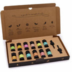 Open cardboard box containing 12 colorful essential oil bottles neatly arranged with two glass droppers, labeled with a guide to essential oils on the inside of the lid.