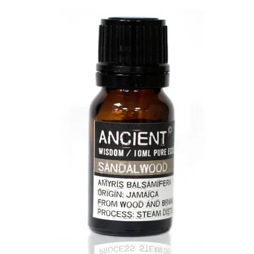 Amber glass bottle of Ancient Wisdom sandalwood essential oil, labeled with origin from Jamaica and details about steam distillation from wood and branches.