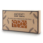 A close-up shot of a brown cardboard gift box for an aromatherapy eye pillow with a giraffe print pattern. The box is stamped with "Ancient Wisdom" and "Relaxing and Therapeutic Eye Pack," promoting a calming home fragrance and aromatherapy experience.