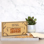 A clean, studio shot of the gift box for an aromatherapy eye pillow with a giraffe pattern. The aromatherapy and home fragrance benefits are highlighted by the "Relaxing and Therapeutic Eye Pack" label.