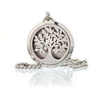 A close-up of a silver-colored essential oil necklace diffuser charm. The charm features a detailed "tree of life" design, showcasing a blend of symbolic jewelry and functional aromatherapy, along with the felt pad near of it where the aromatherapy oil is placed.