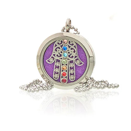 Round silver aroma diffuser pendant with a detailed Hamsa hand design and multicolored gemstones, with a purple felt pad insiede and ball chain.