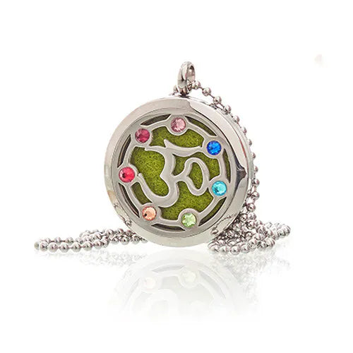 Round aromatherapy diffuser pendant with Om design and gemstones, shown with a green felt pad inside and silver chain.