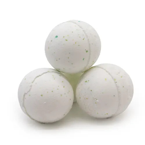 Three white bath bombs stacked in a pyramid formation. Each bath bomb is speckled with small green and yellow particles, giving them a fresh and natural look. The surface shows a slightly textured finish with visible seams from molding.