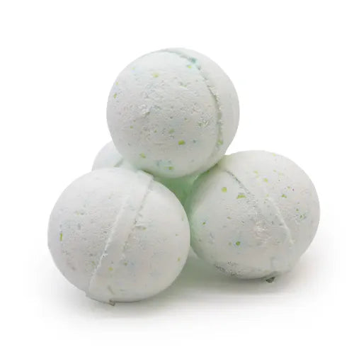 Four pale green bath bombs stacked together in a pyramid. Their surface is speckled with small blue and yellow particles, giving them a refreshing, fizzy look. The texture appears slightly rough, emphasizing their handmade and natural appeal.