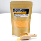 Ancient Wisdom Aromatherapy Bath Potion “Total Detox” kraft pouch with orange bath salts and a wooden scoop spilling some salt onto the surface.