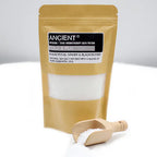 Ancient Wisdom Aromatherapy Bath Potion “Cold & Flu” with eucalyptus, ginger, and black pepper in a brown kraft pouch with visible white bath salts, displayed with a small wooden scoop filled with salts in the foreground.