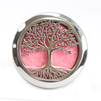Front-facing view of a polished silver tree of life car diffuser, showing its intricate cut-out pattern with a pink felt pad inside, intended for use as an aromatherapy accessory in vehicles.