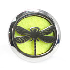 Round stainless steel car diffuser with black dragonfly motif on bright lime yellow felt background. Elegant and symbolic design, ideal for nature lovers who want to enrich their driving experience with soothing, customizable aromas.