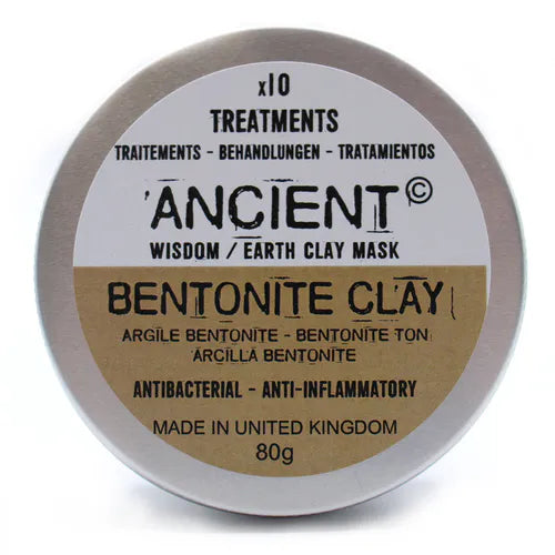 Closed round silver tin of Ancient Wisdom Bentonite Clay mask. The front label highlights "Bentonite Clay" with translations in French, German, and Spanish, and product claims "Antibacterial – Anti-inflammatory." The packaging states "Made in United Kingdom," 80g, and "x10 Treatments." The design emphasizes natural skincare properties.