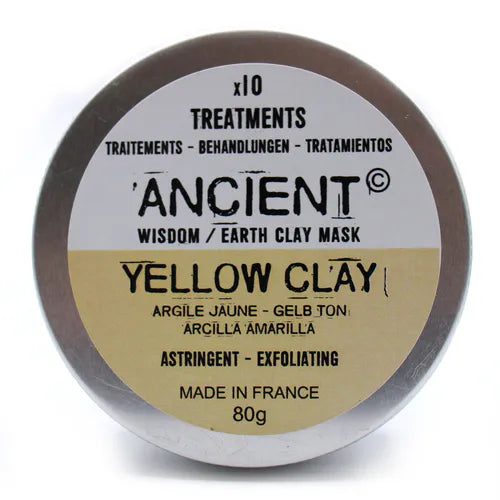 Closed silver tin container of “Ancient Wisdom Earth Clay Mask – Yellow Clay.” The lid label is clearly visible with product details: “x10 Treatments,” “Yellow Clay” in bold black text, translations in other languages, and the description “Astringent – Exfoliating, Made in France, 80g.” The lower half of the label is softly shaded in yellow, emphasizing the clay type.