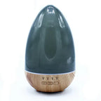 Front view of a teardrop-shaped aroma diffuser with a wooden base and dark transparent top, featuring three buttons (ON, 1H, 3H, 6H) at the base.