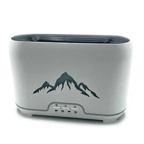 Close-up of a modern, rectangular white aroma diffuser with a black mountain silhouette design on the front and four control buttons below, placed on a white background.