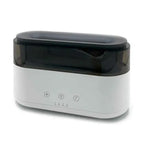 White rectangular aroma diffuser with black transparent top cover and three control buttons on the front, photographed against a plain background.