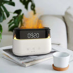 White rectangular aroma diffuser with digital clock display showing 09:20, placed on books with a cup beside it, emitting a realistic flame effect from the top.