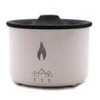 White cylindrical aroma diffuser with black textured top, flame-shaped symbol on the front, and control buttons with timer settings below.