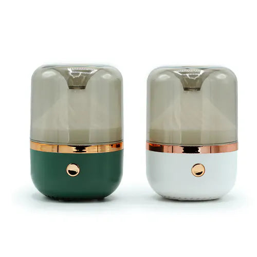 Two round mirror aromatherapy humidifiers, one in green and one in white, with transparent smoke-colored tops and rose gold accents.