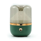 Close-up of a green and gold round mirror aromatherapy humidifier with a smoky transparent top and a single golden button on the front.