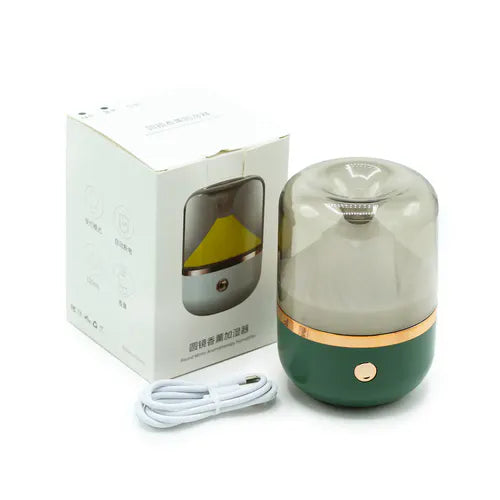 Green and gold round mirror aromatherapy humidifier shown with its packaging box and USB cable, highlighting its elegant design and included accessories.