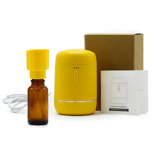 Yellow essential oil diffuser set including diffuser, amber bottle, USB cable, instruction manual, and cardboard box.