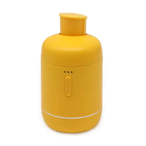 Yellow essential oil diffuser with amber bottle attached on top.
