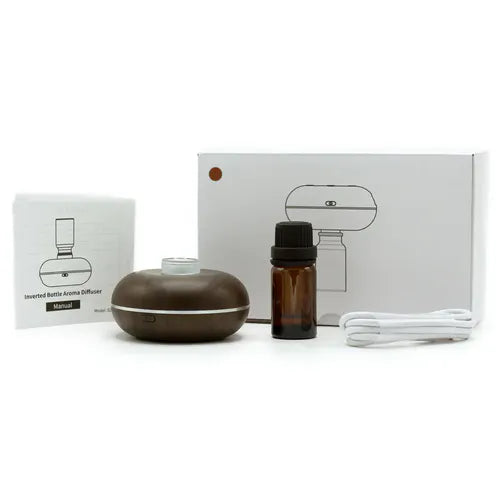 Brown wood grain essential oil diffuser with USB cable, instruction manual, and amber glass bottle placed in front of white packaging box.