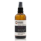 Upright amber spray bottle labeled "Ancient Wisdom Facial Toner Mist Healing Lavender." The label indicates it contains lavender and witch hazel, formulated for calming and healing benefits suitable for all skin types.