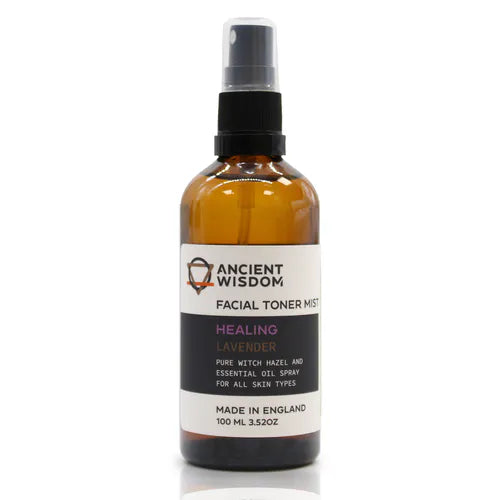 Upright amber spray bottle labeled "Ancient Wisdom Facial Toner Mist Healing Lavender." The label indicates it contains lavender and witch hazel, formulated for calming and healing benefits suitable for all skin types.