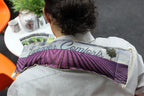 A person wearing a striped shirt with a lavender-themed wheat bag draped across their shoulders. The bag features a purple lavender field design with the words “Lavender Comforts,” providing a soothing and aromatic relaxation aid.
