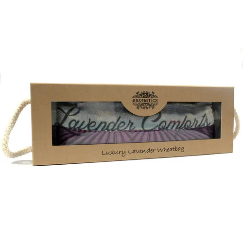 A boxed “Luxury Lavender Wheatbag” by Ancient Wisdom Aromatics. The packaging has a cardboard sleeve with a transparent window showing the lavender-themed fabric bag inside.