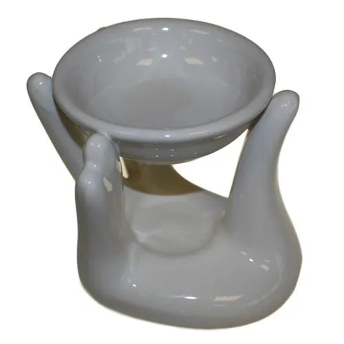 Glossy white ceramic oil burner crafted to resemble a cupped hands holding a round bowl, intended for diffusing oils or wax melts.