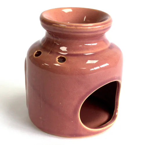 Rear view of a rose glazed ceramic oil burner with glossy finish, showing two round ventilation holes near the neck and a wide arched opening at the base for candle placement.
