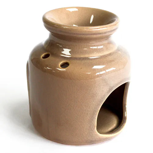 Rear view of a beige glazed ceramic oil burner with glossy finish. The back shows two round ventilation holes and a large arched cut-out at the bottom for a candle.