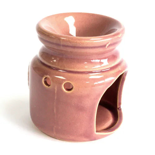 Side view of a glossy rose ceramic oil burner. The back features two round ventilation holes near the neck and a wide cut-out at the base designed to hold a tealight candle.