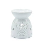 White ceramic oil burner with a rounded bowl-shaped dish on top and a conical base. The base is decorated with carved cut-out patterns featuring a stylized angel with wings, a heart at the center, and surrounding star-shaped cutouts. The glossy finish gives it a smooth and shiny appearance.