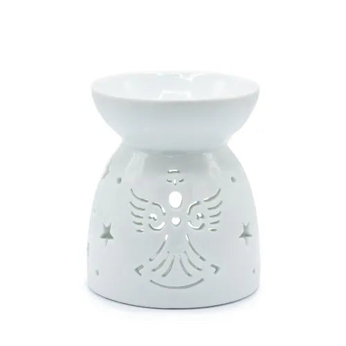 White ceramic oil burner with a rounded bowl-shaped dish on top and a conical base. The base is decorated with carved cut-out patterns featuring a stylized angel with wings, a heart at the center, and surrounding star-shaped cutouts. The glossy finish gives it a smooth and shiny appearance.