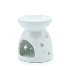 Rear view of white ceramic oil burner with a glossy finish, featuring a rounded bowl-shaped dish on top and a conical base. The base has several star-shaped and circular cutouts, along with a large arched opening in the front for placing a tealight candle. The polished surface reflects light, emphasizing its smooth texture.