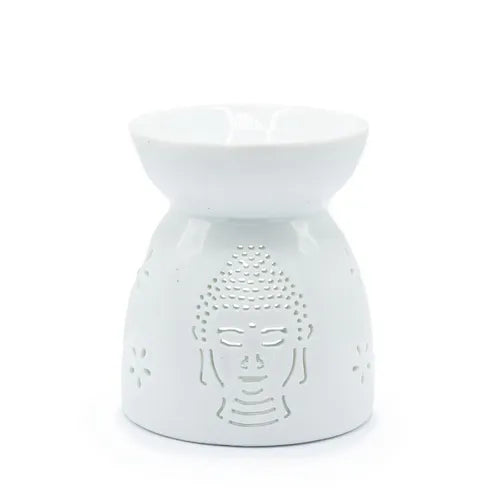 White ceramic oil burner with a wide shallow bowl on top and a perforated design of a Buddha face on the front, surrounded by small floral cutouts.