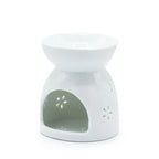 Rear view white ceramic oil burner with a wide shallow bowl on top and a large open cavity at the front, decorated with small perforated floral patterns on the sides.