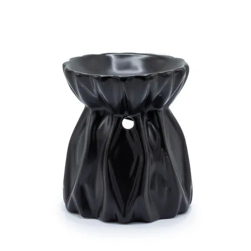 Black ceramic oil burner with a unique draped fabric-like texture, featuring a wide rounded bowl at the top and a small circular cutout in the center of the body for ventilation. The surface has a smooth, glossy finish, creating the appearance of flowing folds.