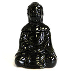 Glossy black ceramic Buddha-shaped oil burner viewed from the front, with the Buddha seated in a meditative posture. The sculpture has a detachable head that fits neatly on the upper part, and the robe details are visible with intricate folds.