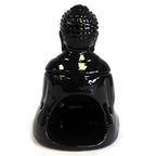 Glossy black ceramic Buddha-shaped oil burner viewed from the back, with a hollow opening at the base for a tealight candle. The piece has a detachable head that forms the upper part of the sculpture, showing curled hair texture on the head.