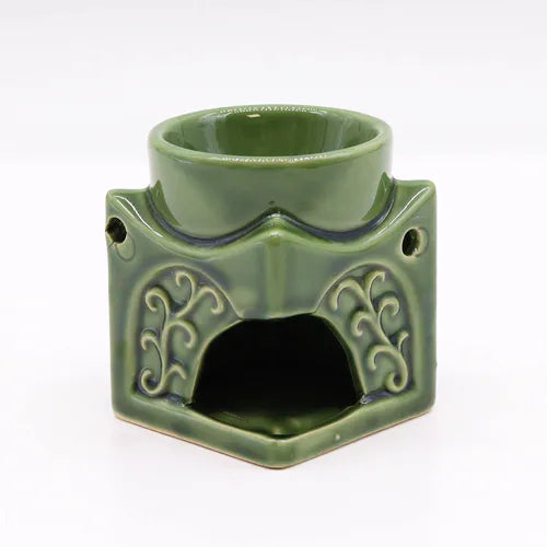 Rear view of a green ceramic Buddha oil burner with hexagonal base, intricate floral patterns, and a round top dish for oils or wax melts. The open cavity at the bottom is meant for placing a tealight candle, making it a decorative and functional aromatherapy accessory.