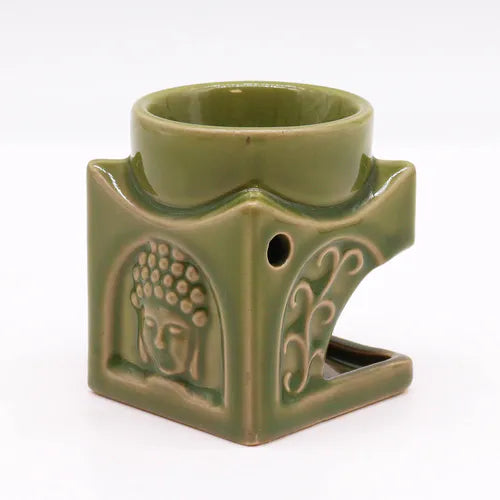 Side view of a green ceramic Buddha oil burner with detailed embossed patterns, featuring a serene Buddha face and decorative swirls, designed for aromatherapy and home fragrance.
