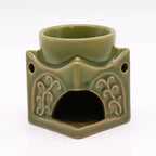 Back view of a green ceramic Buddha oil burner with arched opening for tealight candle placement, decorated with embossed swirls, ideal for essential oils and incense.