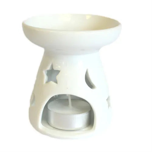A compact, white ceramic oil and wax melt warmer with a star and moon cutout design. essential oil diffuser features a wide top dish for wax or oil and a base with an arched opening to insert a tea light candle. A tea light is shown inside, demonstrating how the cutouts create a celestial glow. The product is photographed against a clean white background. This elegant oil burner is ideal for aromatherapy, creating a cozy ambiance